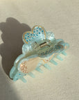 A 10cm celestial-themed acetate hair clip in light blue with a moon motif with rhinestone accent