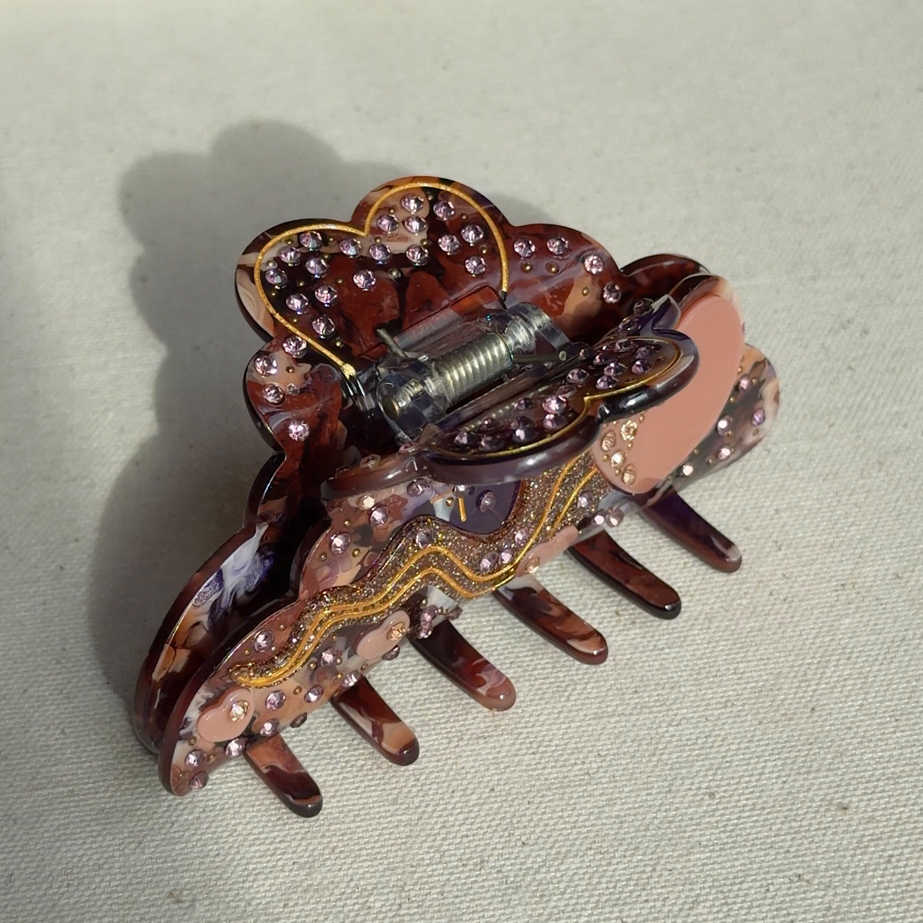 A 10cm celestial-themed acetate hair clip in burgundy with a moon motif with rhinestone accent