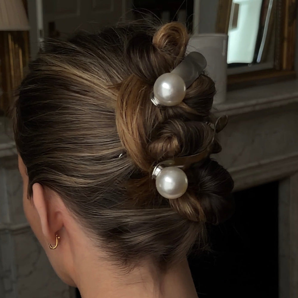Person with styled hair up in a wedding style hair with pearl hair clips like bridal hair