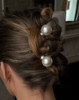 Person with styled hair up in a wedding style hair with pearl hair clips like bridal hair
